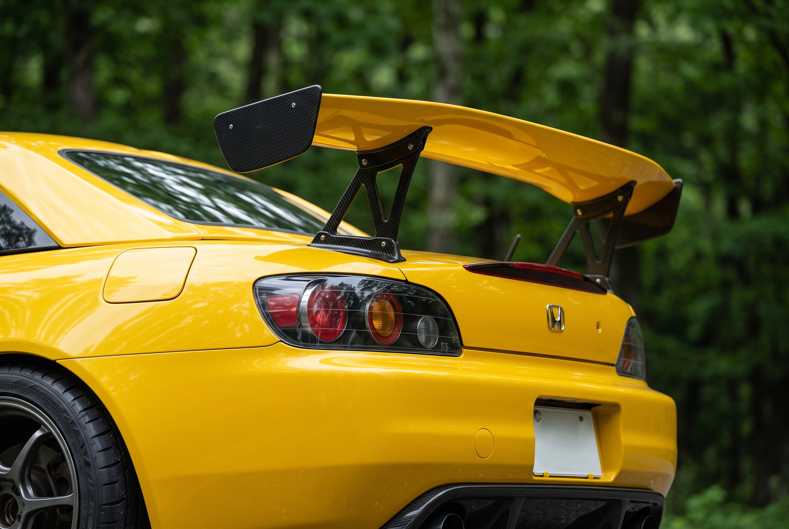 大型のカーボン製GTウイングとディフューザーを装着した、鮮やかなイエローのホンダ S2000のリアビュー。
